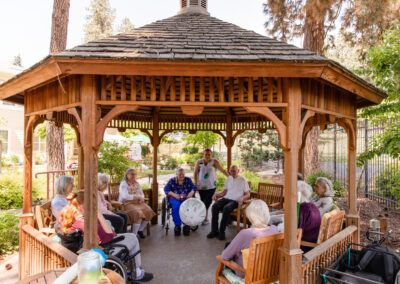 group of elderly residents playing with a beach ball under a gazebo