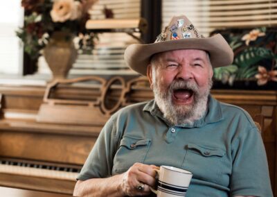 laughing elderly man holding coffee mug