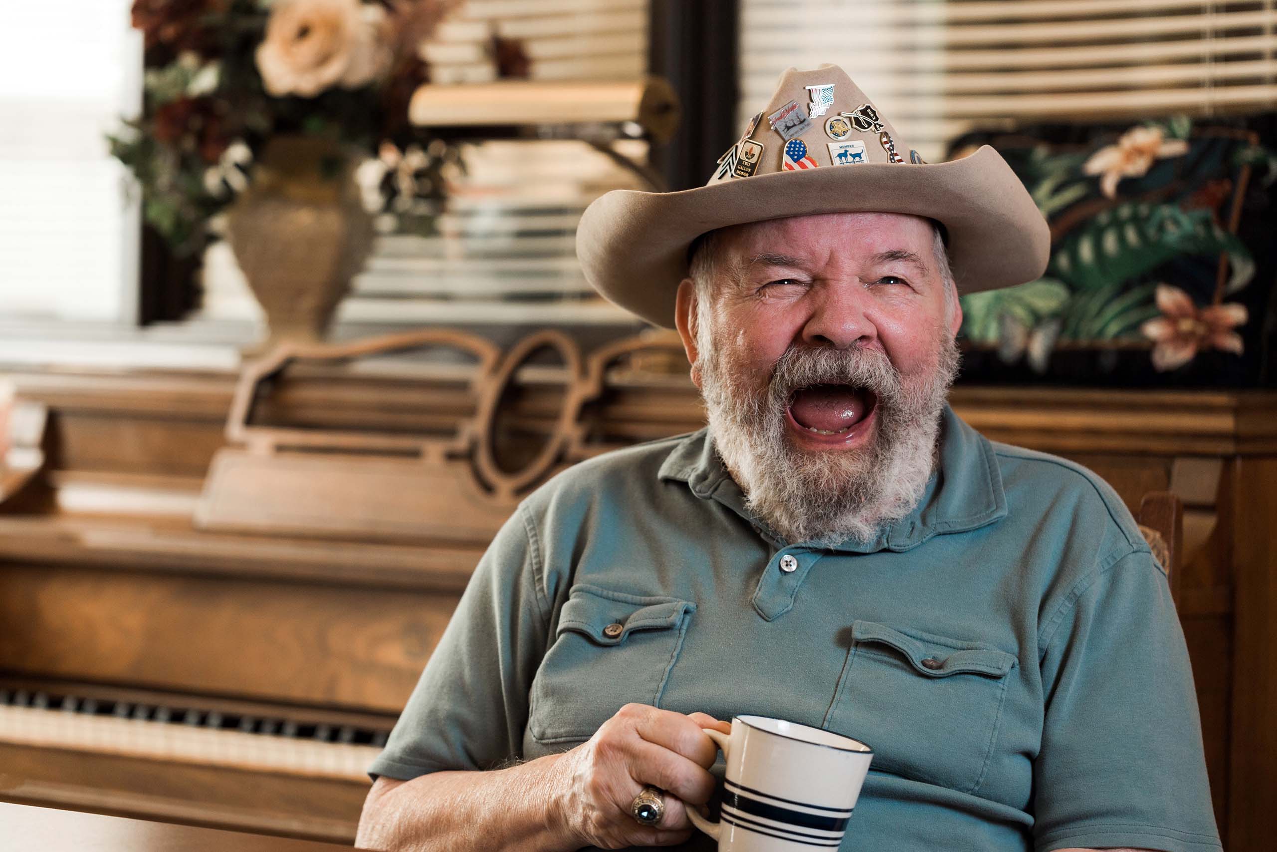 laughing elderly man holding coffee mug