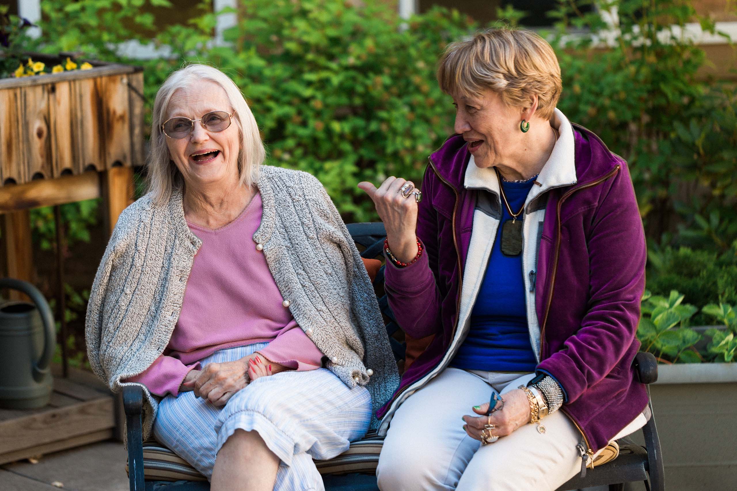 two elderly women seated together and smiling