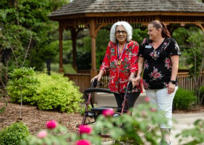 smiling elderly woman walking with care giver