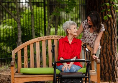 smiling women at a garden bench