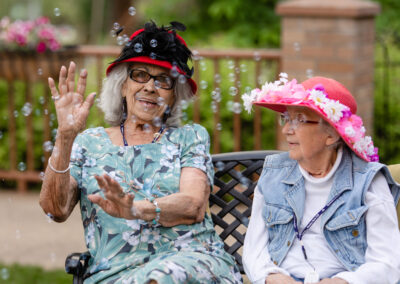 smiling elderly women blowing bubbles