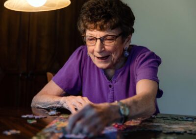 smiling elderly woman working on a puzzle