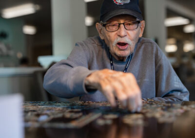 happy elderly man working on puzzle