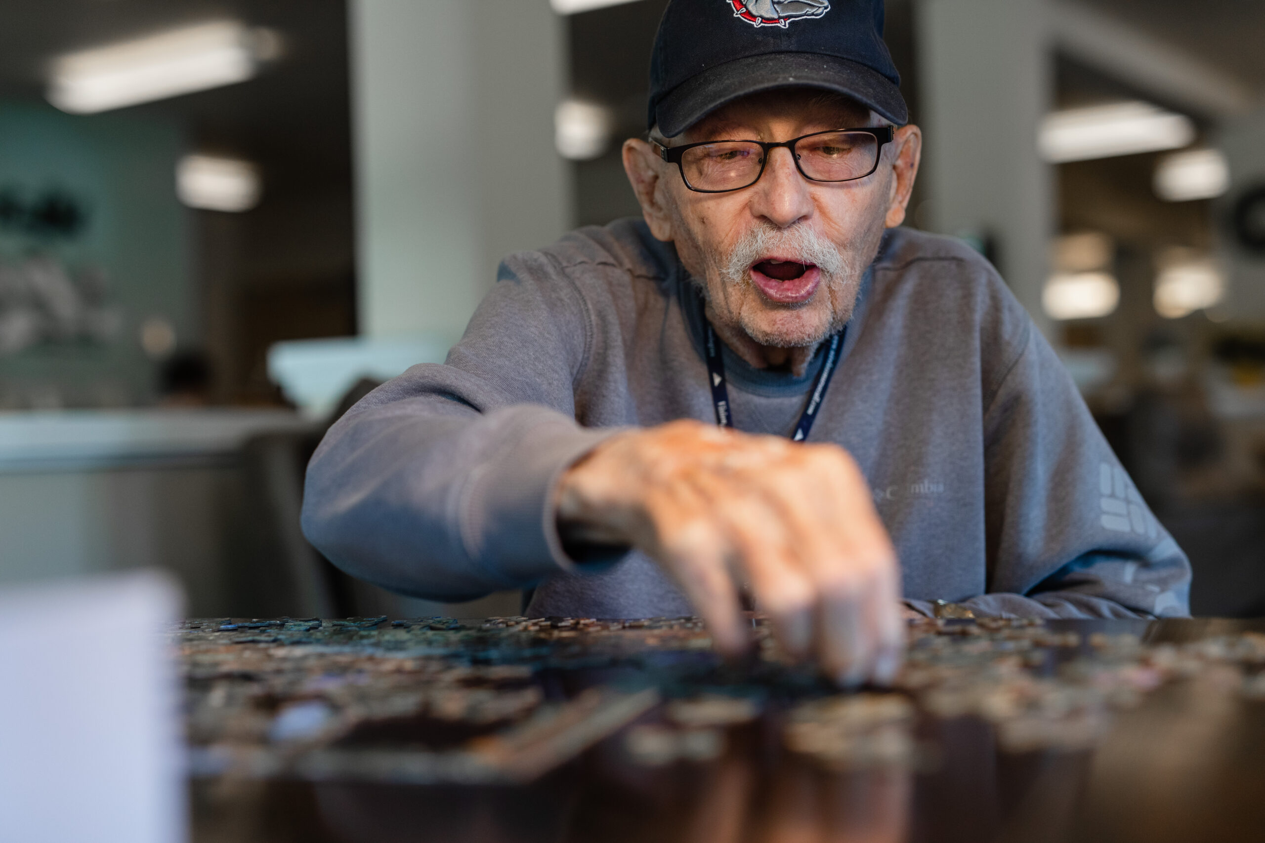 happy elderly man working on puzzle