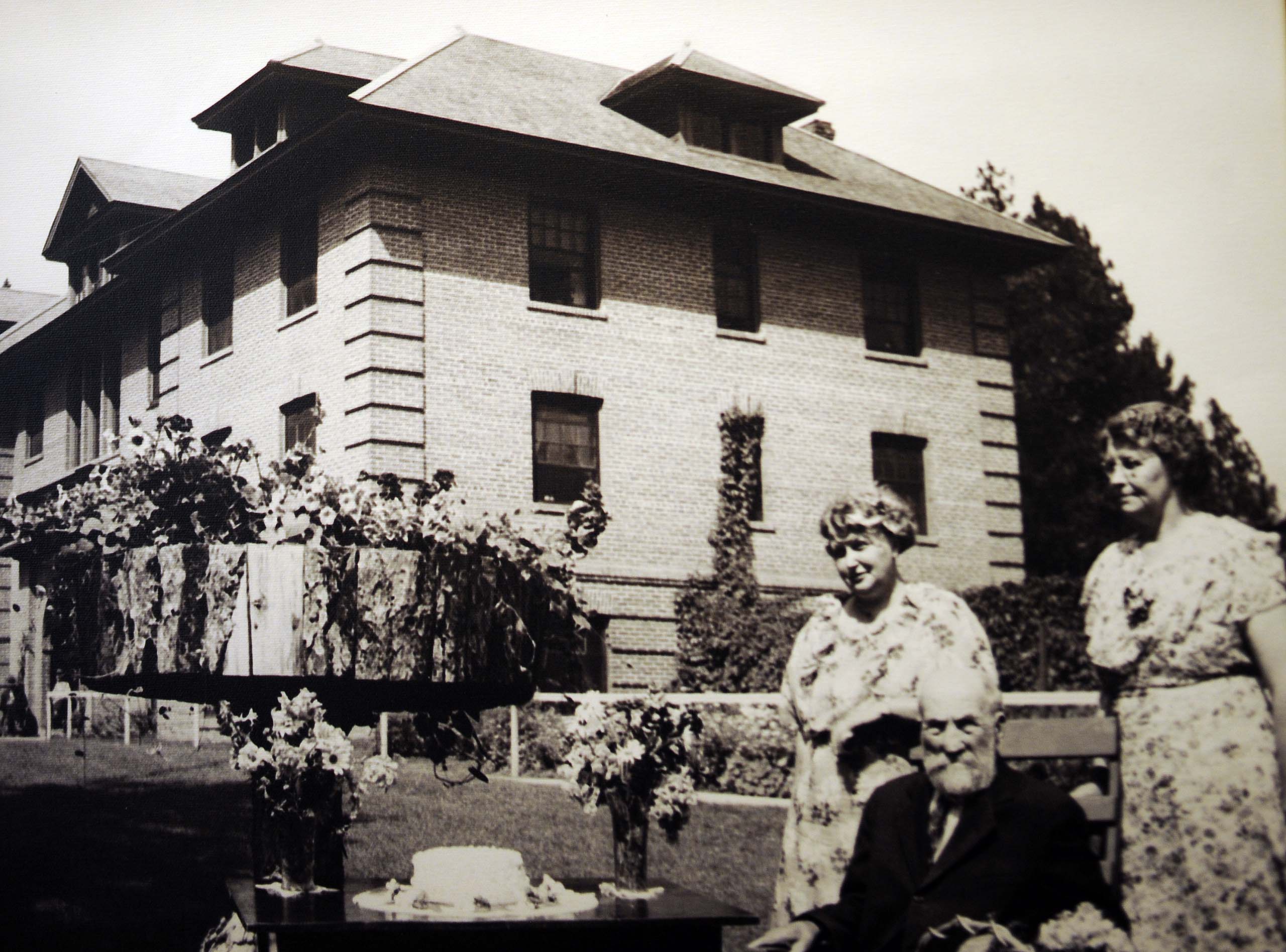 care givers and residents standing outside original building